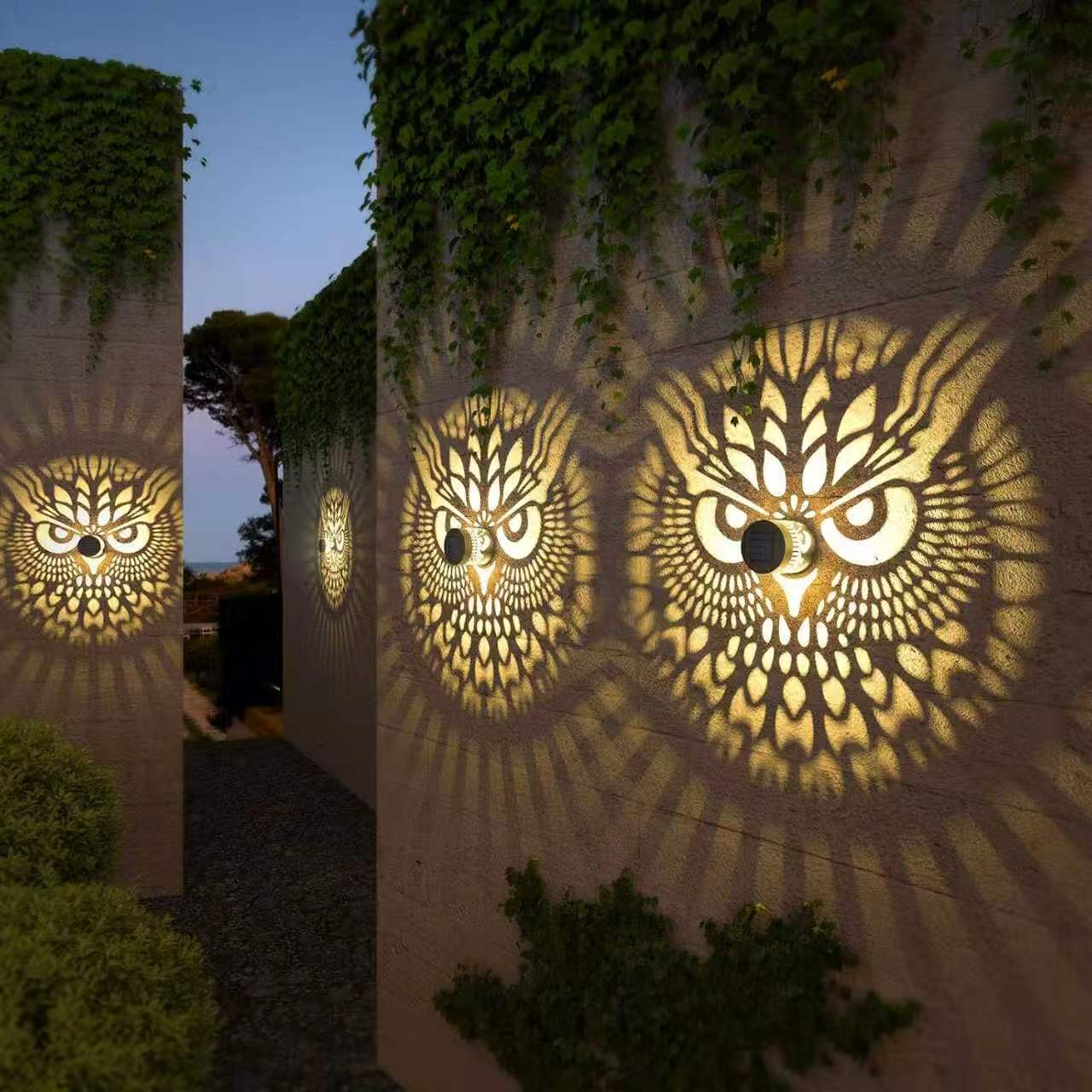 Multiple AML2166 Owl solar shadow patterns on an outdoor garden wall
