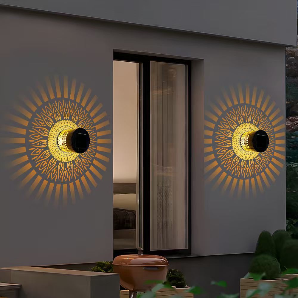 Two warm-white life-wheel solar projection lights beside an outdoor doorway