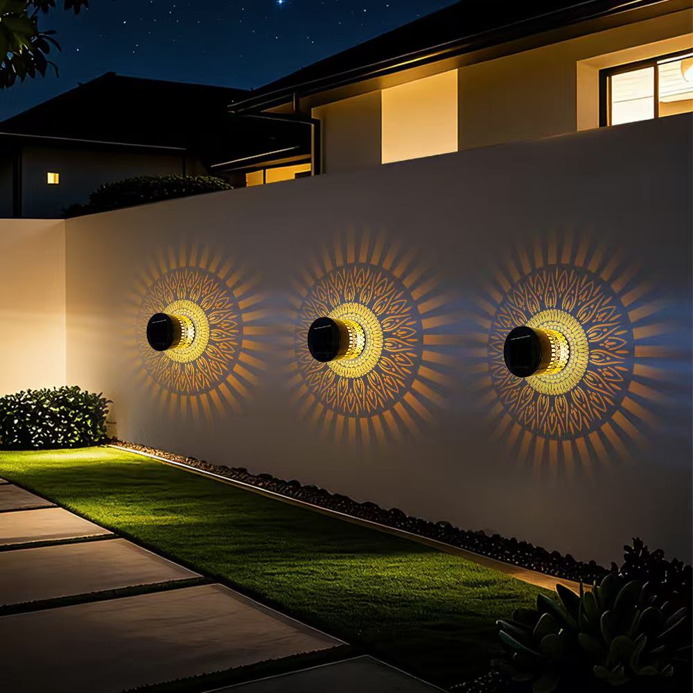 Three life-wheel solar projection lights arranged on a long garden wall