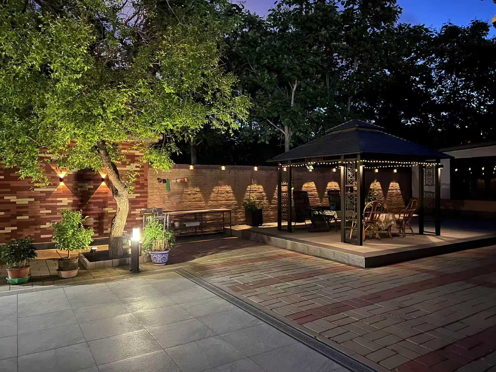 Real garden and gazebo installation with repeated wall lights